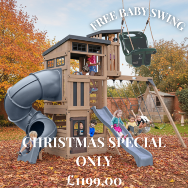 This image is an advertisement for a large wooden outdoor play structure/swing set. Here are the key details visible in the ad: Product: A multi-level playhouse with a tube slide, an open slide, and a swing set attached. Special Offer: "FREE BABY SWING" is included as part of the "CHRISTMAS SPECIAL". Price: £1199.00 Setting: The playset is shown outdoors in a garden setting, likely in Autumn, with many fallen leaves on the ground. Several children are playing on the structure.